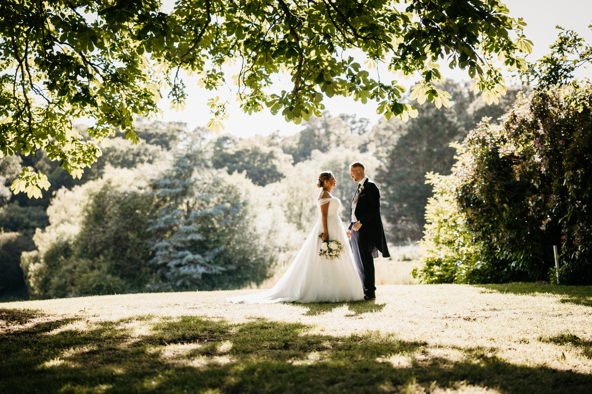 Bride and Groom having wedding photo taken at golden hour at The Post Barn in Newbury 